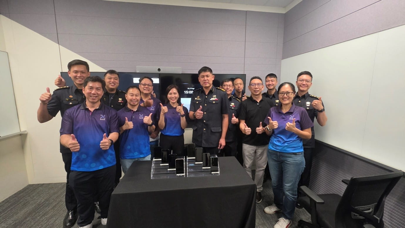 Group of people posing for a photo, giving thumbs-up gestures.